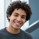 Headshot portrait of a smiling young adult, conveying happiness and trust.